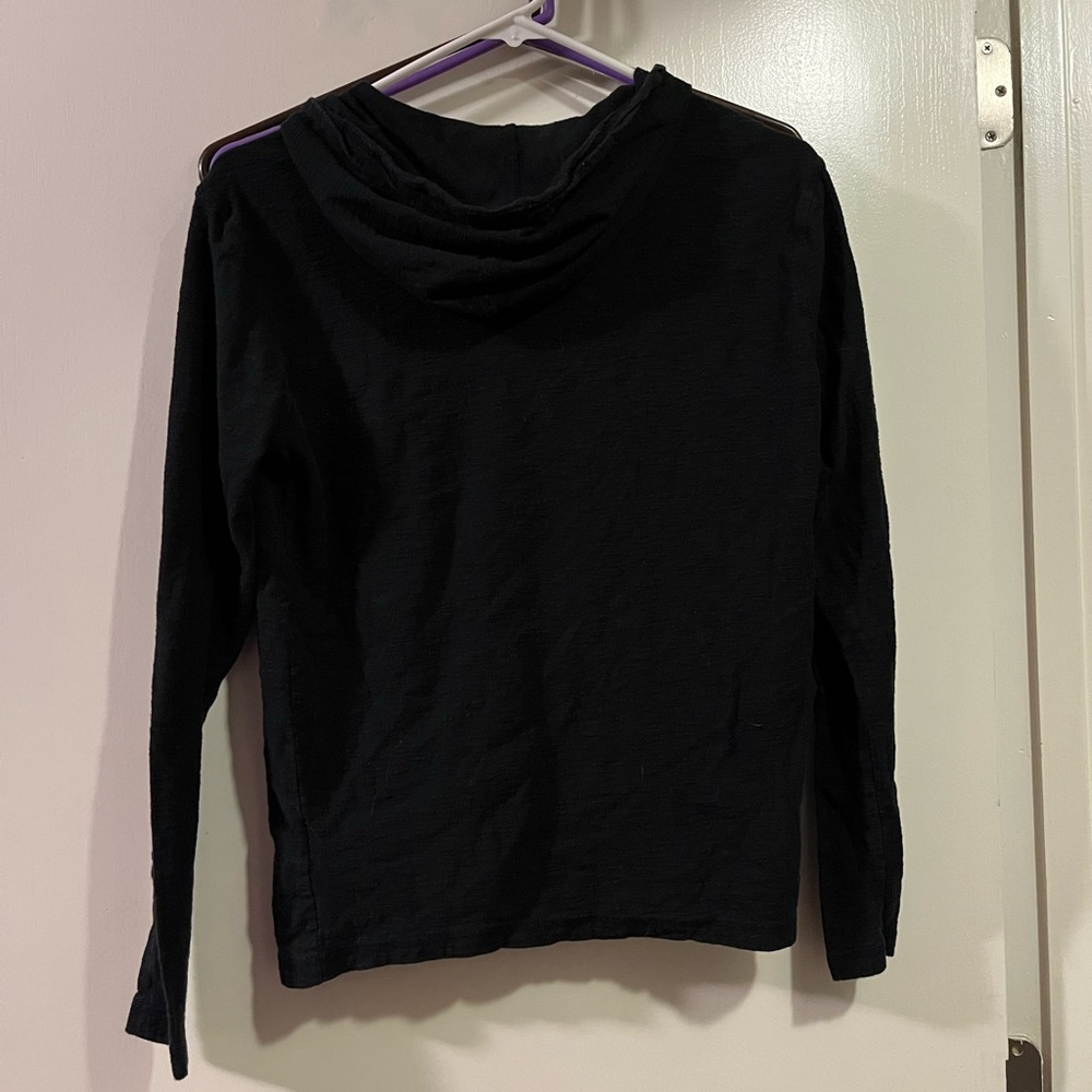 Black long sleeve shirt with hood and buttoned v-neck, two pockets in the front